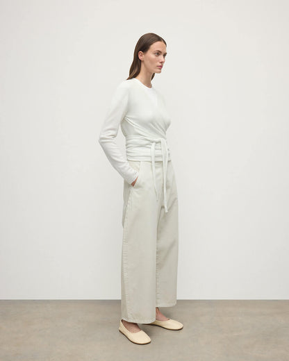 Model wearing Johnstons of Elgin AW25 Women's Knitwear White Featherlight Cashmere Ballet Wrap with white trousers on a light background KAP05408HA0346