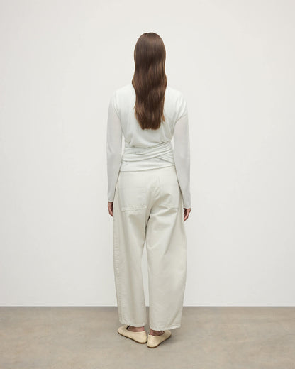 Model wearing Johnstons of Elgin AW25 Women's Knitwear White Featherlight Cashmere Ballet Wrap with white trousers on a light background KAP05408HA0346