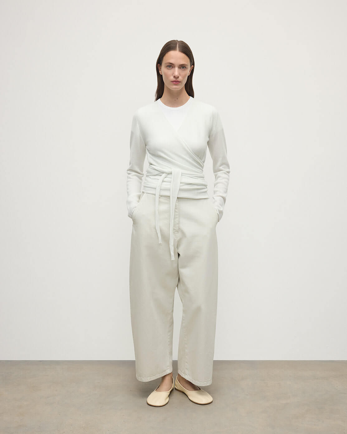 Model wearing Johnstons of Elgin AW25 Women's Knitwear White Featherlight Cashmere Ballet Wrap with white trousers on a light background KAP05408HA0346