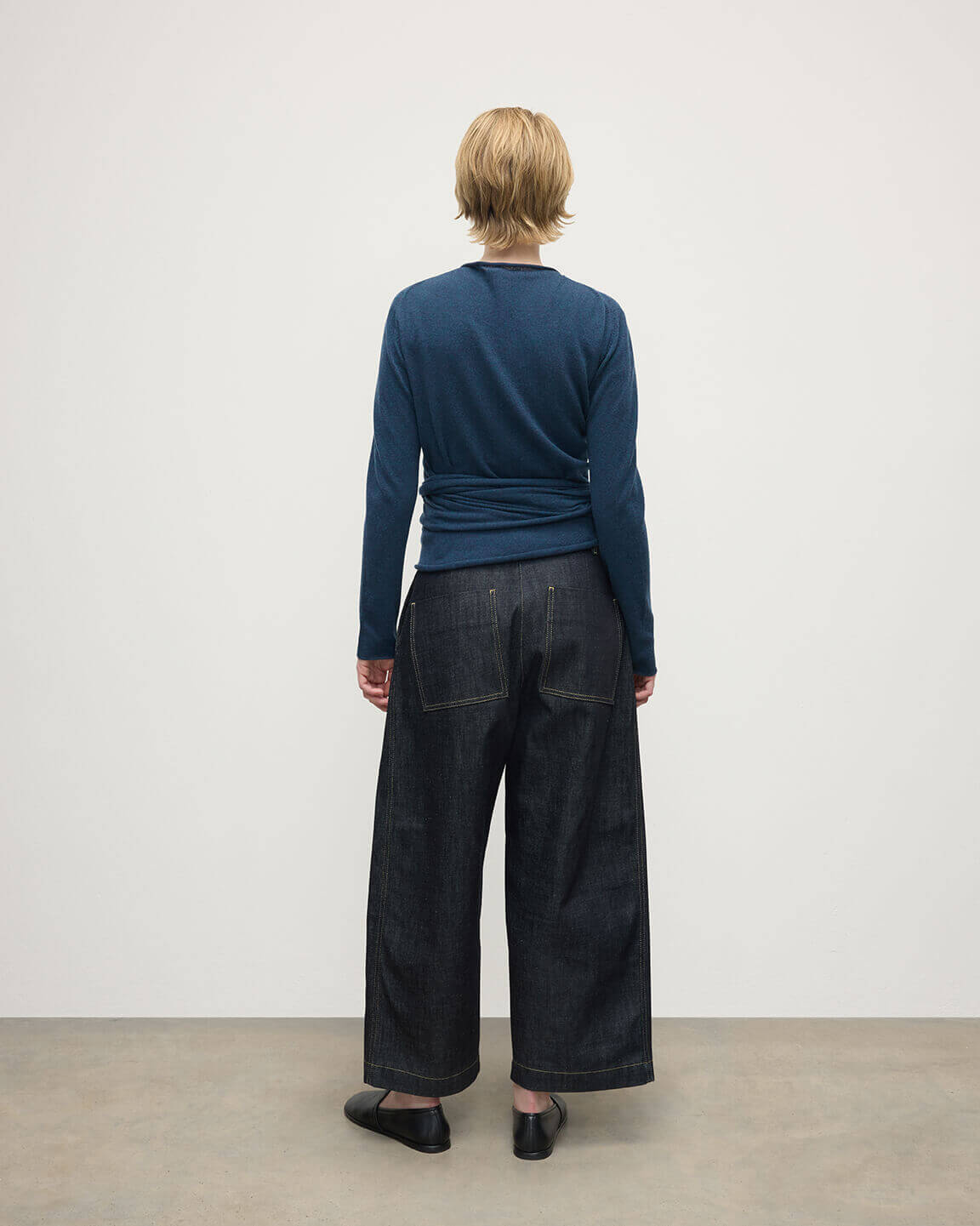 Model wears Johnstons of Elgin AW25 Women's Knitwear Heather Navy Ballet Wrap Navy Cashmere Cardigan Back View KAP05408HD7321