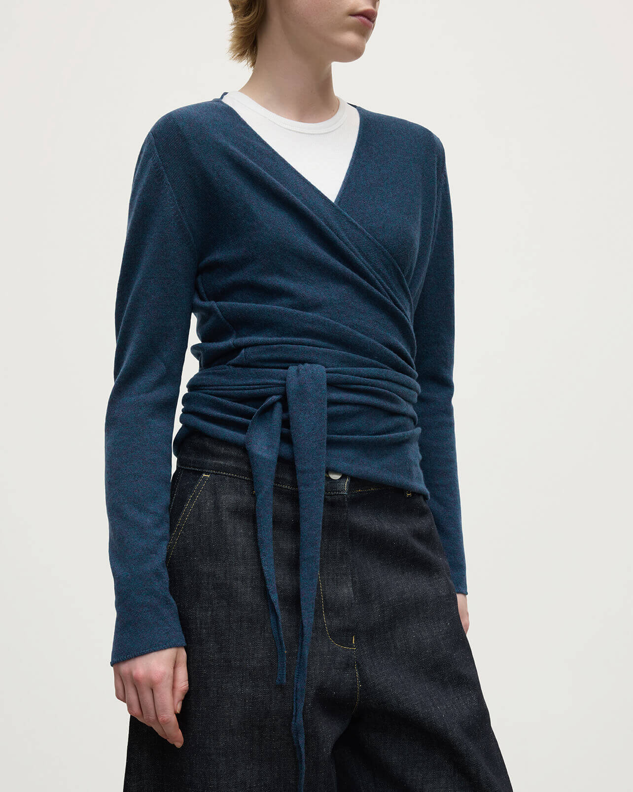 Model wears Johnstons of Elgin AW25 Women's Knitwear Heather Navy Ballet Wrap Navy Cashmere Cardigan Close Up  KAP05408HD7321