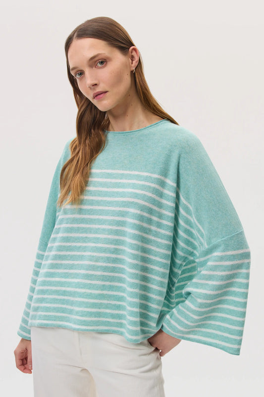 Model wearing Johnstons of Elgin SS25 Women's Knitwear Jade & White Relaxed Featherlight Cashmere Stripe Jumper with white jeans 
 KAP05425Q25141