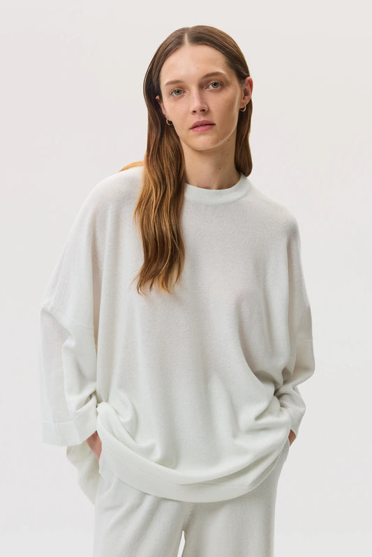 Model wears Johnstons of Elgin SS25 Women's Knitwear White Relaxed Featherlight Cashmere Jumper with white cashmere culottes  KAP05426HA0346