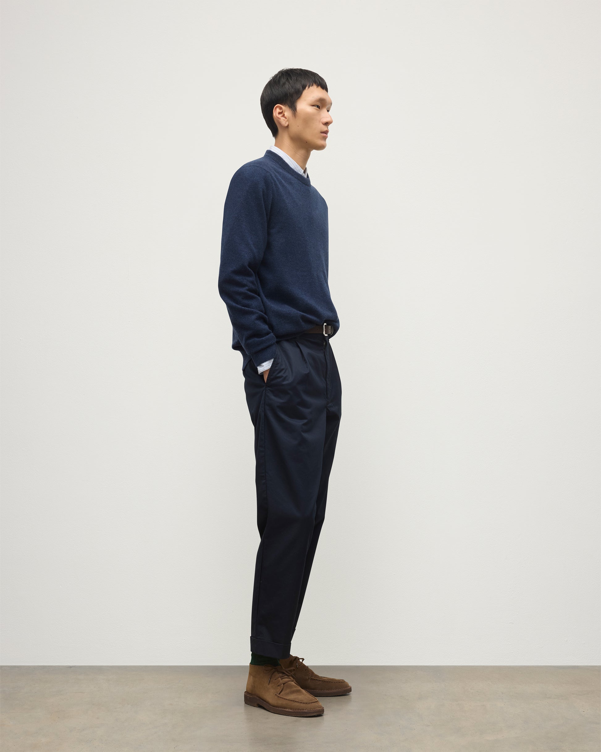 MODEL WEARS JOHNSTONS OF ELGIN MENS RORY CREW CLASSIC JUMPER NAVY 100% CASHMERE OVER A LIGHT BLUE SHIRT WITH NAVY TROUSERS KAP05471HD7350