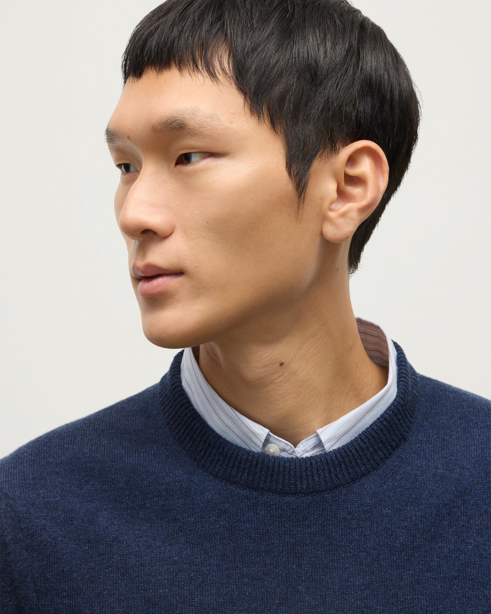 MODEL WEARS JOHNSTONS OF ELGIN MENS RORY CREW CLASSIC JUMPER NAVY 100% CASHMERE OVER A LIGHT BLUE SHIRT  KAP05471HD7350