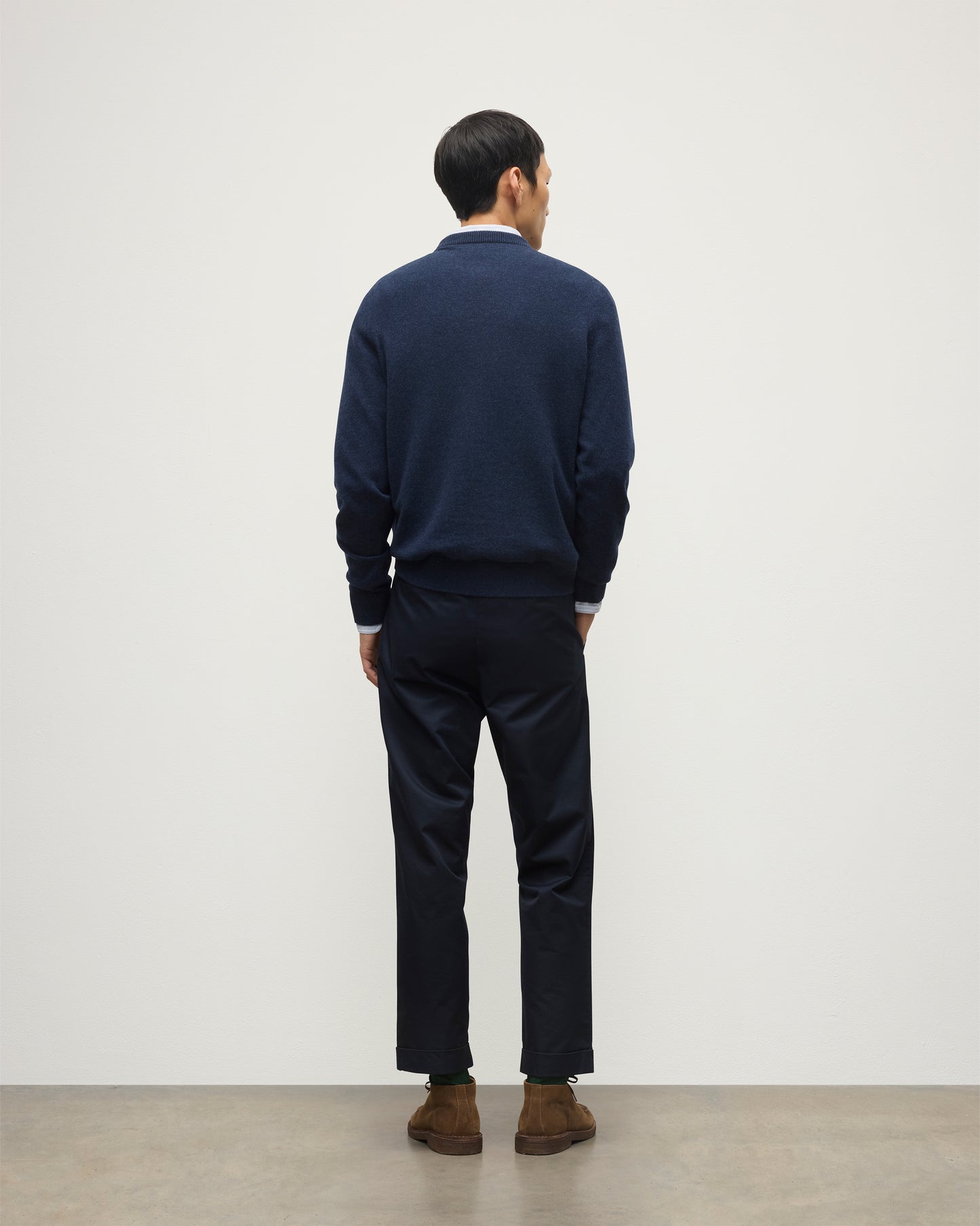 MODEL WEARS JOHNSTONS OF ELGIN MENS RORY CREW CLASSIC JUMPER NAVY 100% CASHMERE OVER A LIGHT BLUE SHIRT WITH NAVY TROUSERS KAP05471HD7350