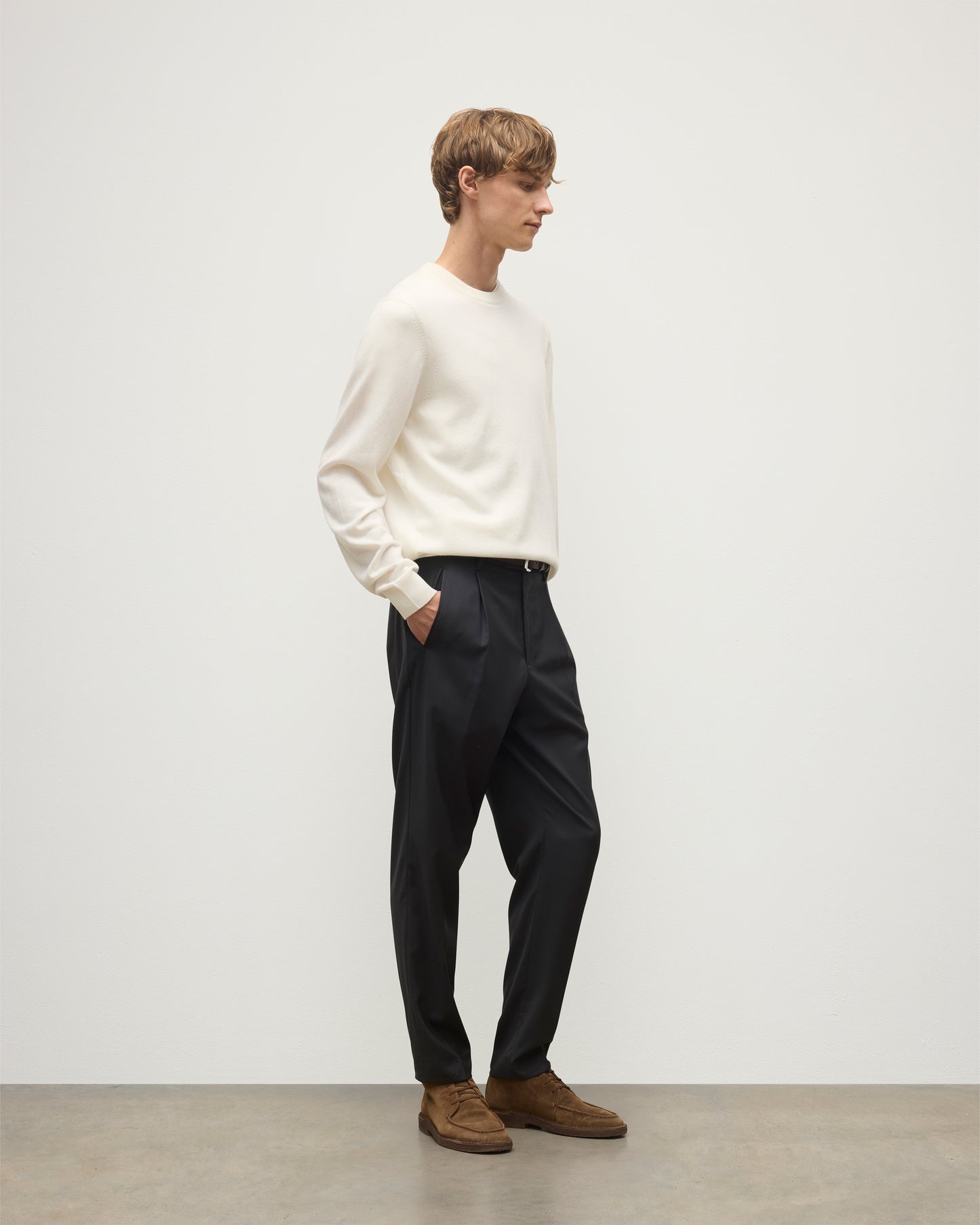 MODEL WEARS JOHNSTONS OF ELGIN MENS RORY CREW CLASSIC JUMPER WHITE 100% CASHMERE WITH GREY TROUSERS AND BROWN BELT AND SHOES KAP05471SA0606