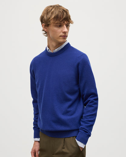MODEL WEARS JOHNSTONS OF ELGIN MENS RORY CREW CLASSIC JUMPER BLUE 100% CASHMERE OVER A LIGHT BLUE SHIRT KAP05471SD5326
