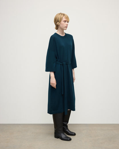 Model wears Johnstons of Elgin AW25 Women's Knitwear Bottle Green Tie-Waist Cashmere Green Jumper Dress Side View  KAP05490SC7341