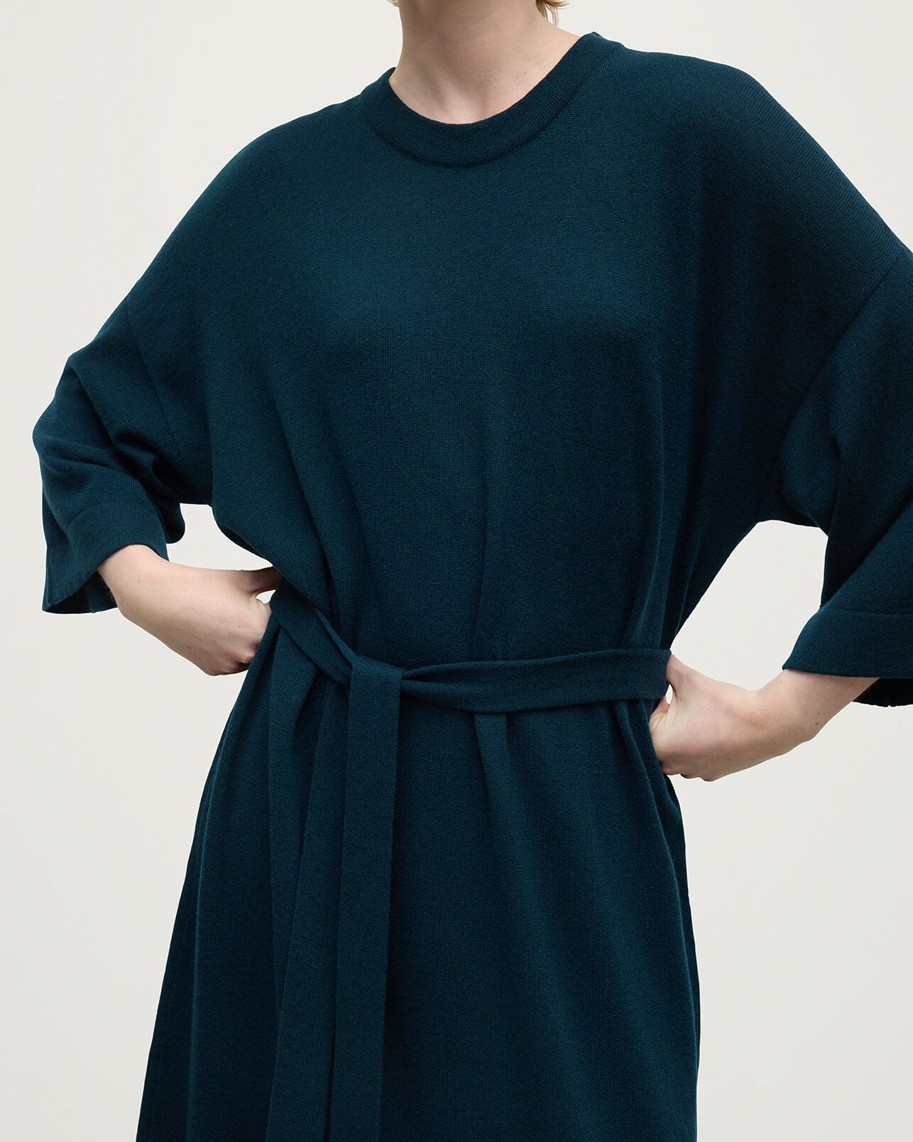 Model wears Johnstons of Elgin AW25 Women's Knitwear Bottle Green Tie-Waist Cashmere Green Jumper Dress Details  KAP05490SC7341