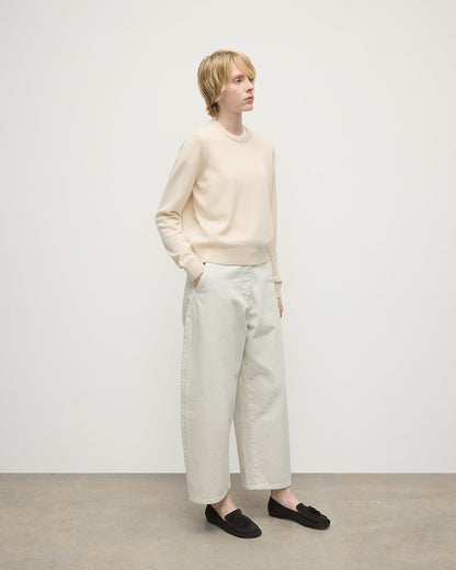 model wearing Johnstons of Elgin AW25 Women's Knitwear Champagne Classic Cashmere Cream Round Neck Jumper Side View KAP05572SA0502