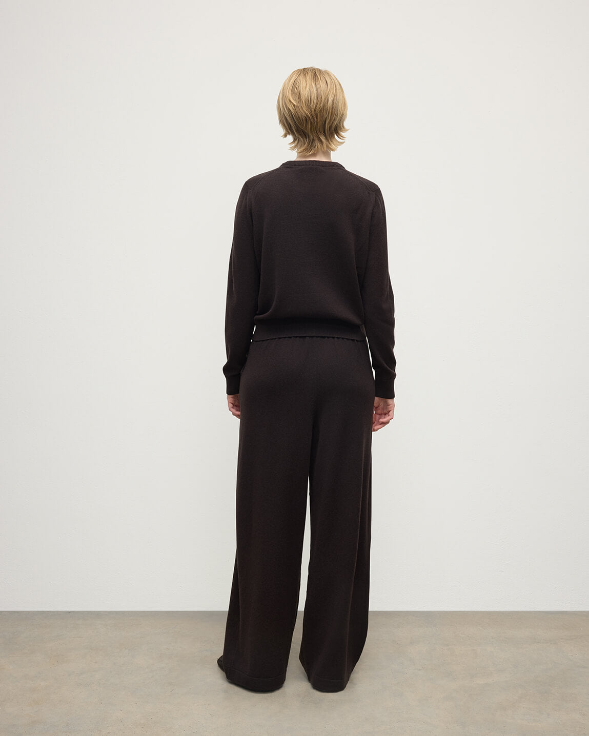 Model wearing Johnstons of Elgin AW25 Women's Knitwear Molasses Classic Cashmere Brown Round Neck Jumper back View KAP05572SB7290