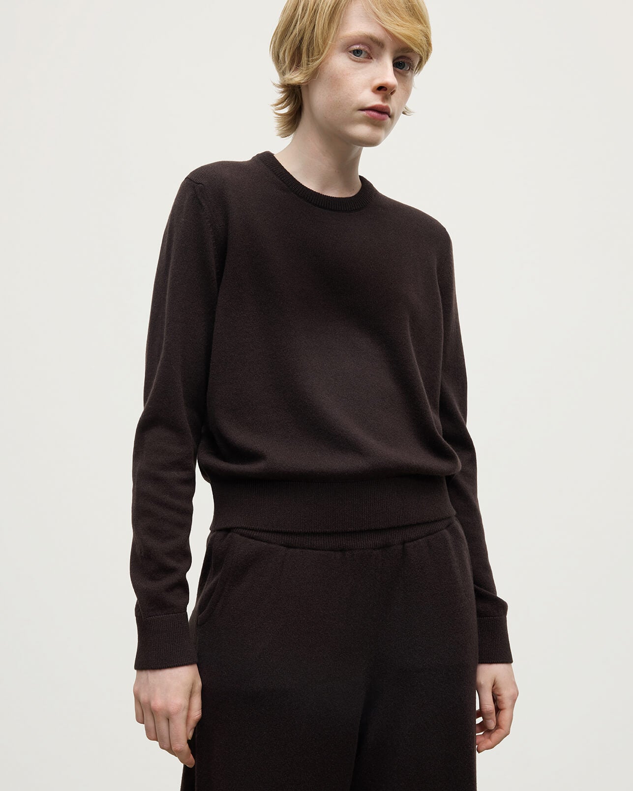 Model wearing Johnstons of Elgin AW25 Women's Knitwear Molasses Classic Cashmere Brown Round Neck Jumper Close Up KAP05572SB7290