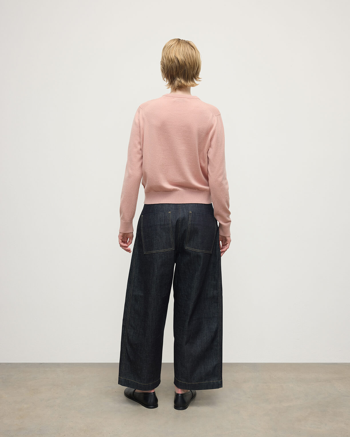 Model wears Johnstons of Elgin AW25 Women's Knitwear Nude Classic Cashmere Pink Round Neck Jumper Back View KAP05572SE0740