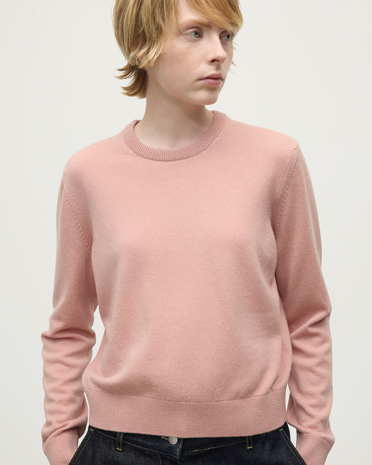 Model wears Johnstons of Elgin AW25 Women's Knitwear Nude Classic Cashmere Pink Round Neck Jumper Close Up KAP05572SE0740