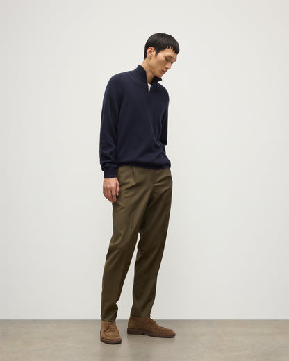 MODEL WEARS JOHNSTONS OF ELGIN MENS RORY CLASSIC HALF ZIP SWEATER CONTRAST TRIM NAVY & CHARCOAL 100% CASHMERE, OVER A WHITE T-SHIRT WITH OLIVE GREEN TROUSERS KAP05577Q26187