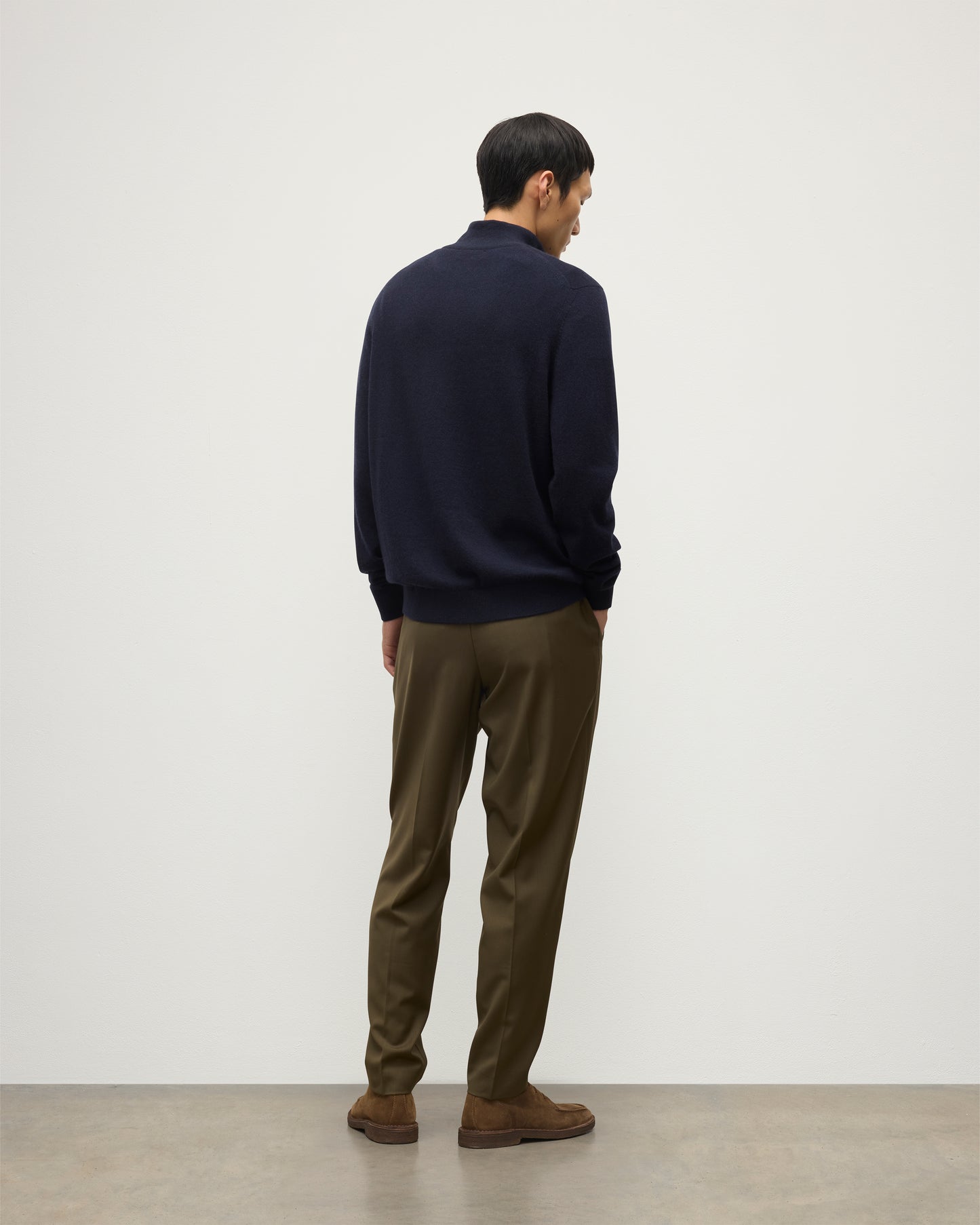 MODEL WEARS JOHNSTONS OF ELGIN MENS RORY CLASSIC HALF ZIP SWEATER CONTRAST TRIM NAVY & CHARCOAL 100% CASHMERE, OVER A WHITE T-SHIRT WITH OLIVE GREEN TROUSERS KAP05577Q26187