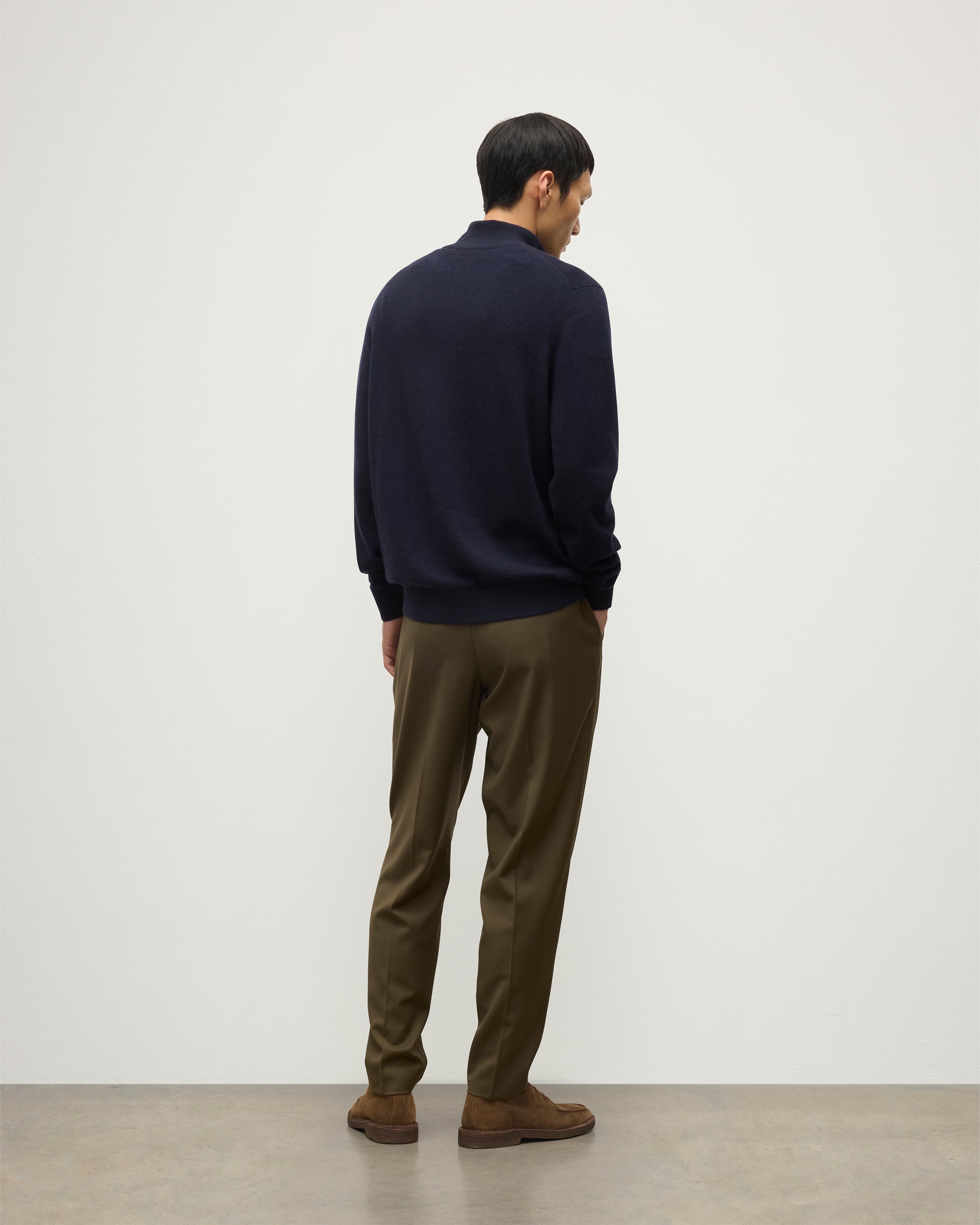 MODEL WEARS JOHNSTONS OF ELGIN MENS RORY CLASSIC HALF ZIP SWEATER CONTRAST TRIM NAVY & CHARCOAL 100% CASHMERE, OVER A WHITE T-SHIRT WITH OLIVE GREEN TROUSERS KAP05577Q26187