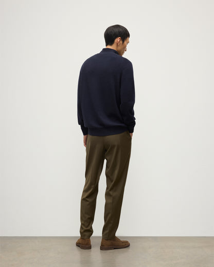 MODEL WEARS JOHNSTONS OF ELGIN MENS RORY CLASSIC HALF ZIP SWEATER CONTRAST TRIM NAVY & CHARCOAL 100% CASHMERE, OVER A WHITE T-SHIRT WITH OLIVE GREEN TROUSERS KAP05577Q26187