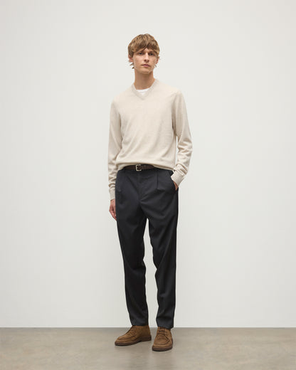 MODEL WEARS JOHNSTONS OF ELGIN MENS RORY VEE NECK CLASSIC JUMPER NATURAL 100% CASHMERE, OVER A WHITE T-SHIRT WITH NAVY TROUSERS  KAP05594HA0402