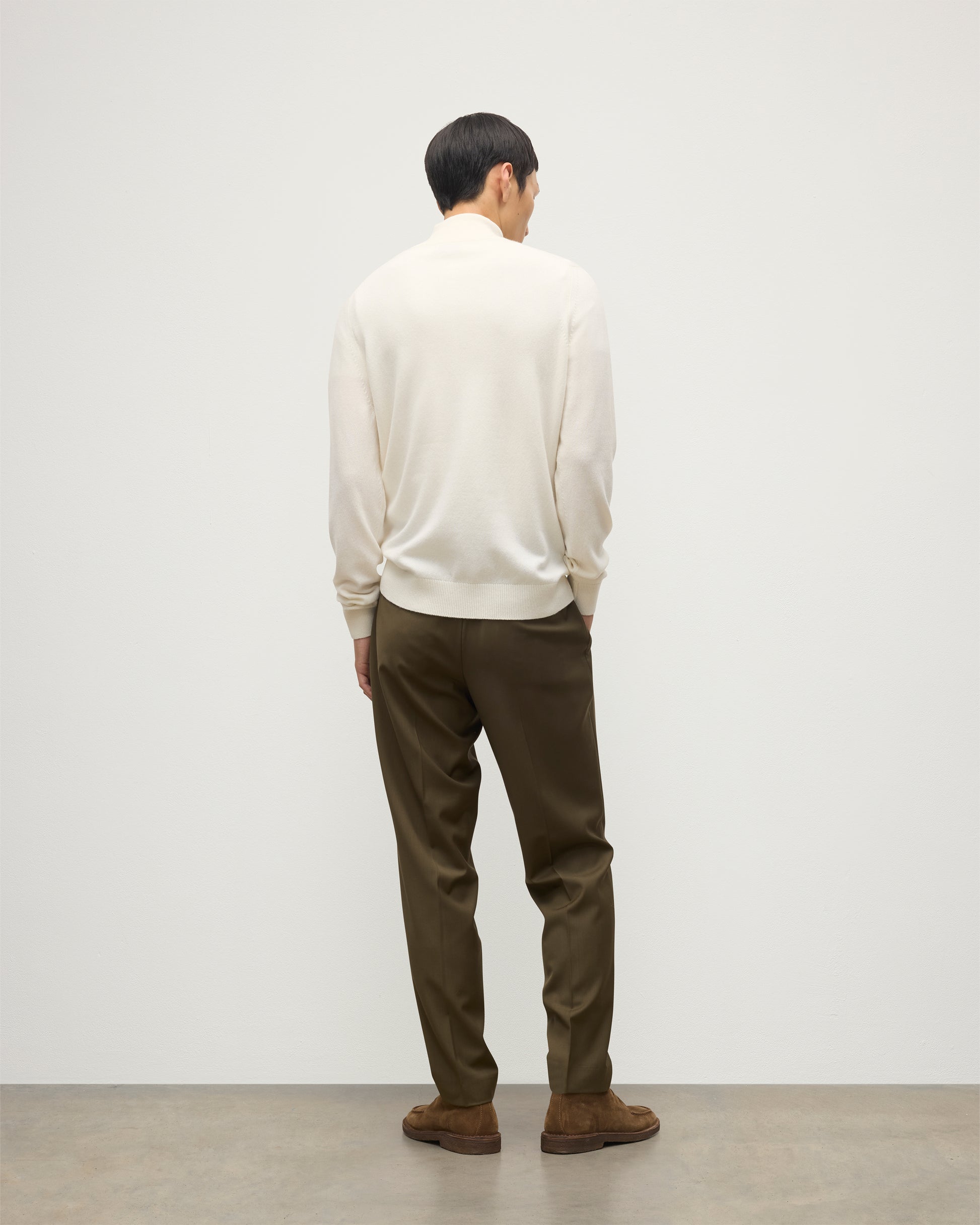 MODEL WEARS JOHNSTONS OF ELGIN MENS RORY CLASSIC HALF ZIP CLASSIC SWEATER 100% CASHMERE OVER A WHITE T-SHIRT WITH OLIVE GREEN TROUSERS KAP05695SA0606