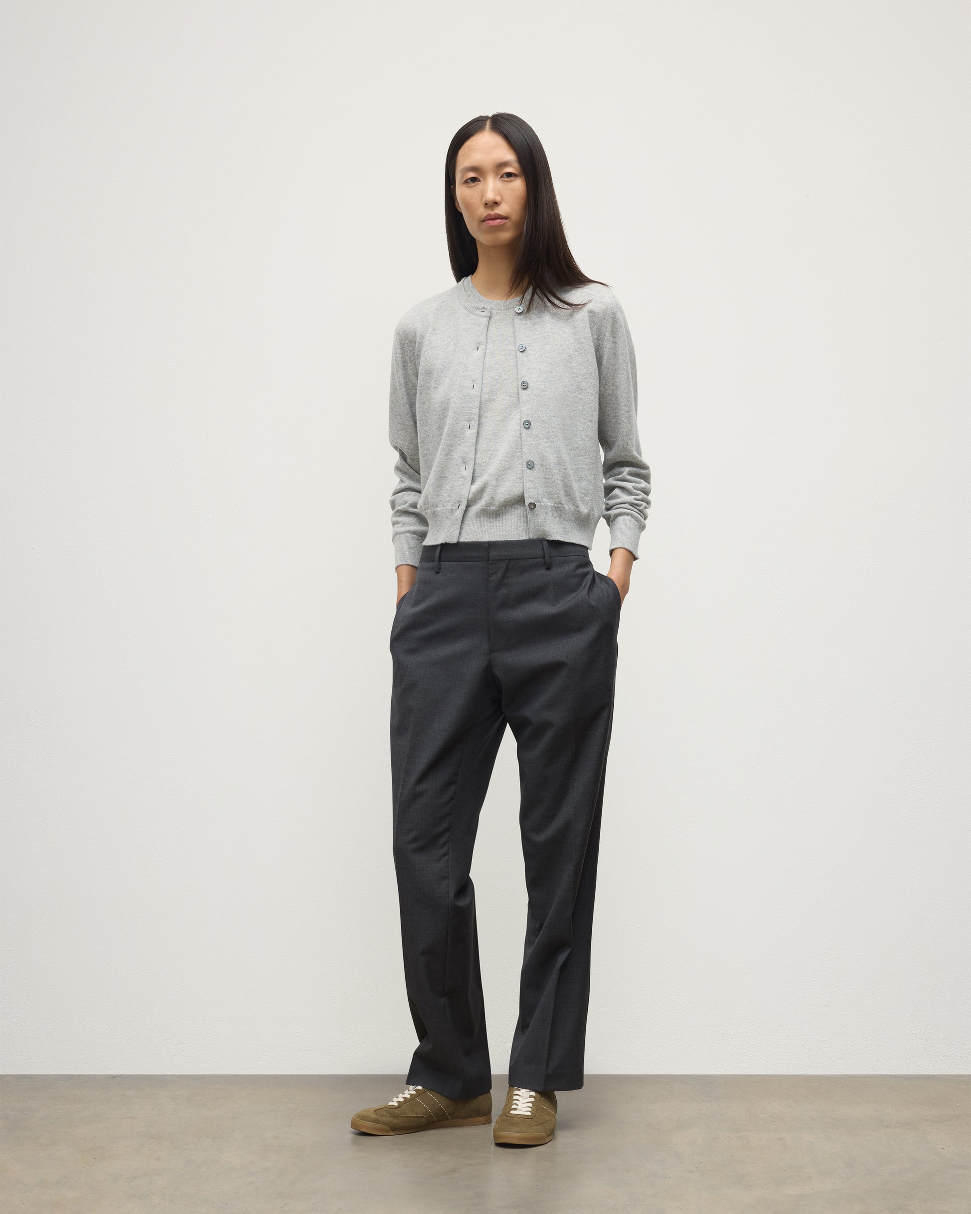 MODEL WEARS JOHNSTONS OF ELGIN WOMENS IRIS CLASSIC CREW CARDIGAN GREY WITH GREY TROUSERS AND TRAINERS  100% CASHMERE KAP05704HA0399