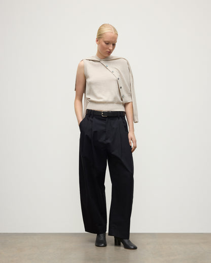 MODEL WEARS JOHNSTONS OF ELGIN WOMENS IRIS CLASSIC SLEEVELESS CREW NATURAL 100% CASHMERE WITH MATCHING CARDIGAN DRAPED OVER SHOULDERS, WITH NAVY TROUSERS AND BLACK BOOTS  KAP05705HA0402