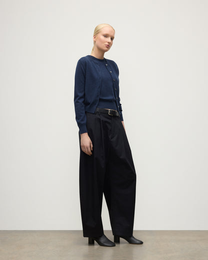 MODEL WEARING JOHNSTONS OF ELGIN WOMENS IRIS CLASSIC CREW CARDIGAN NAVY 100% CASHMERE, OVER A MATCHING SLEEVELESS TANK WITH NAVY TROUSERS, BLANK BOOTS KAP05704HD7350