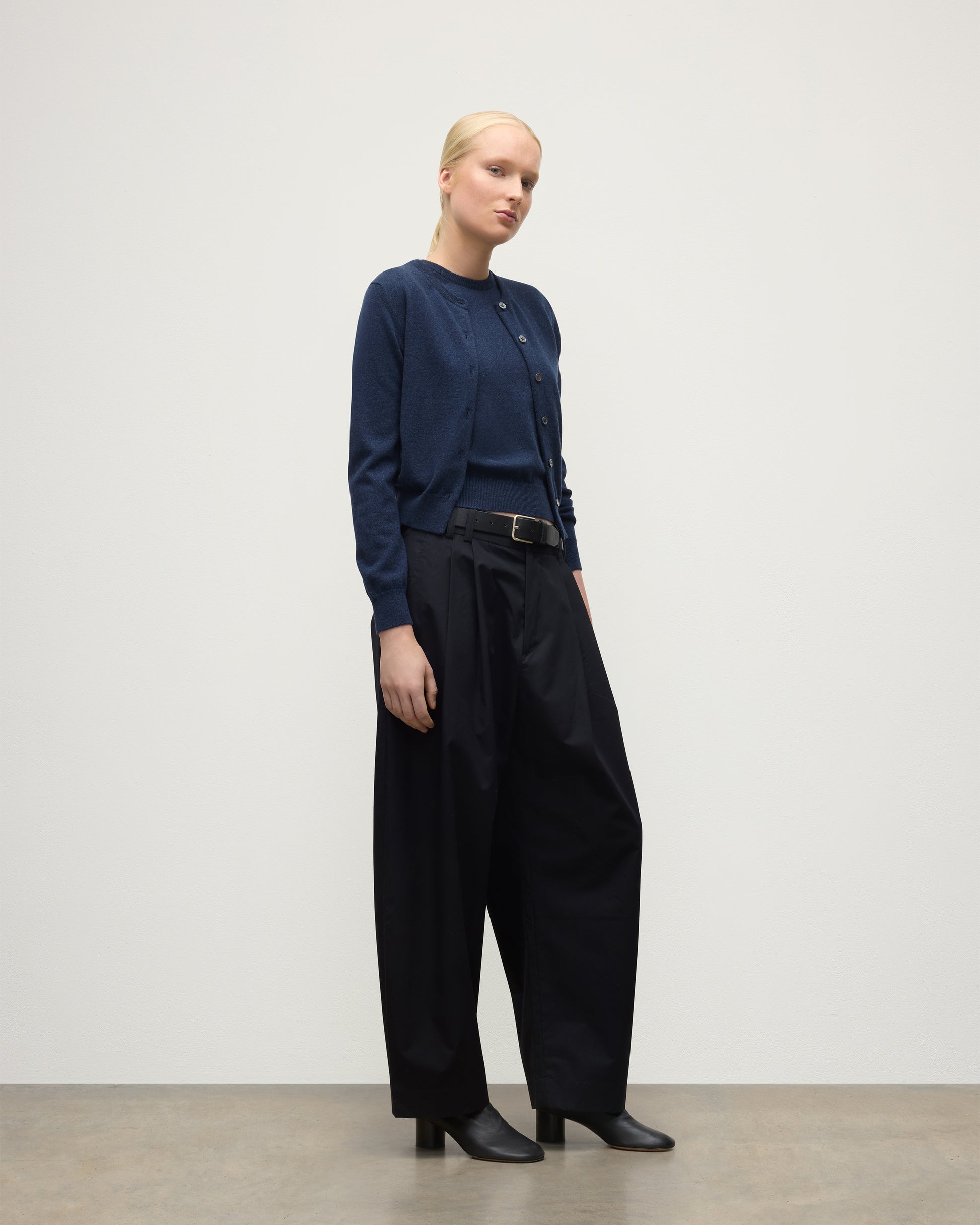 MODEL WEARING JOHNSTONS OF ELGIN WOMENS IRIS CLASSIC CREW CARDIGAN NAVY 100% CASHMERE, OVER A MATCHING SLEEVELESS TANK WITH NAVY TROUSERS, BLANK BOOTS KAP05704HD7350