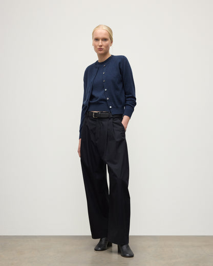 MODEL WEARING JOHNSTONS OF ELGIN WOMENS IRIS CLASSIC CREW CARDIGAN NAVY 100% CASHMERE, OVER A MATCHING SLEEVELESS TANK WITH NAVY TROUSERS, BLANK BOOTS KAP05704HD7350