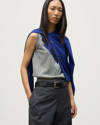 MODEL WEARING JOHNSTONS OF ELGIN WOMENS IRIS CLASSIC CREW CARDIGAN BLUE 100% CASHMERE OVER LE JABOT CASHMERE TANK WITH GREY TROUSERS AND BLACK BOOTS KAP05704SD5326