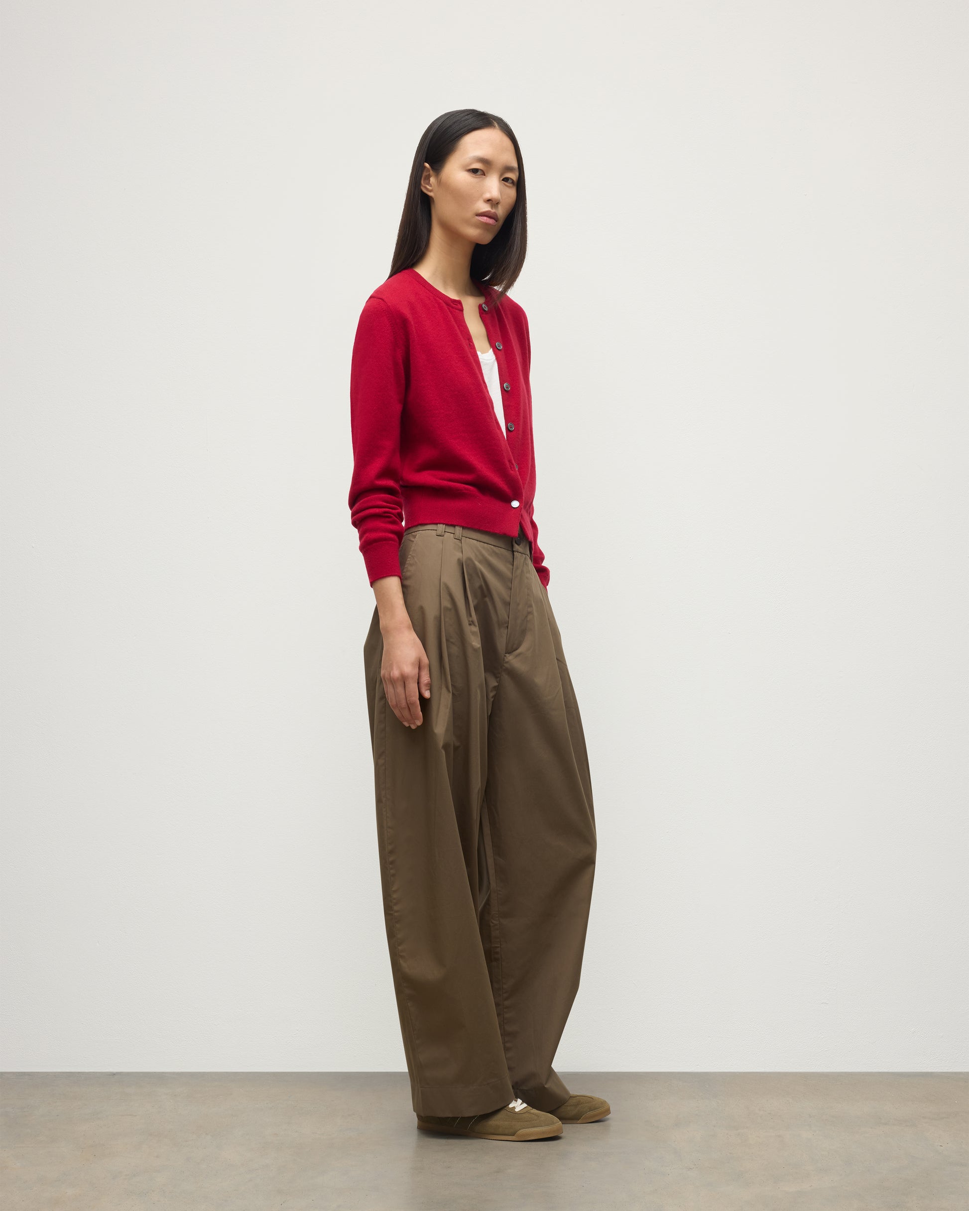 MODEL WEARS JOHNSTONS OF ELGIN WOMENS IRIS CLASSIC CREW CARDIGAN RED 100% CASHMERE OVER A WHITE VEST WITH BROWN TROUSERS AND TRAINERS  KAP05704SE5325