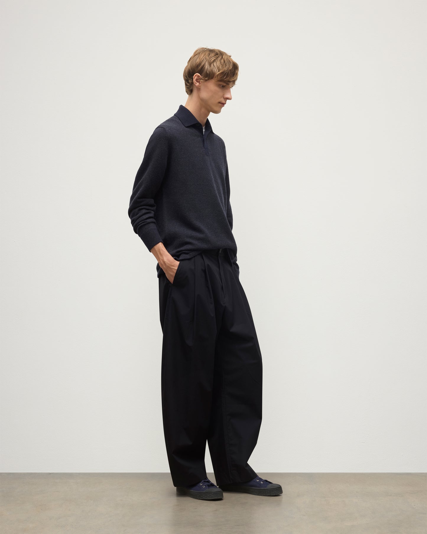 MODEL WEARS JOHNSTONS OF ELGIN MENS TWEEL RUGBY SHIRT NAVY & DARK GREY 100% CASHMERE  OVER A WHITE T-SHIRT WITH GREY TROUSERS KAP05727Q25937