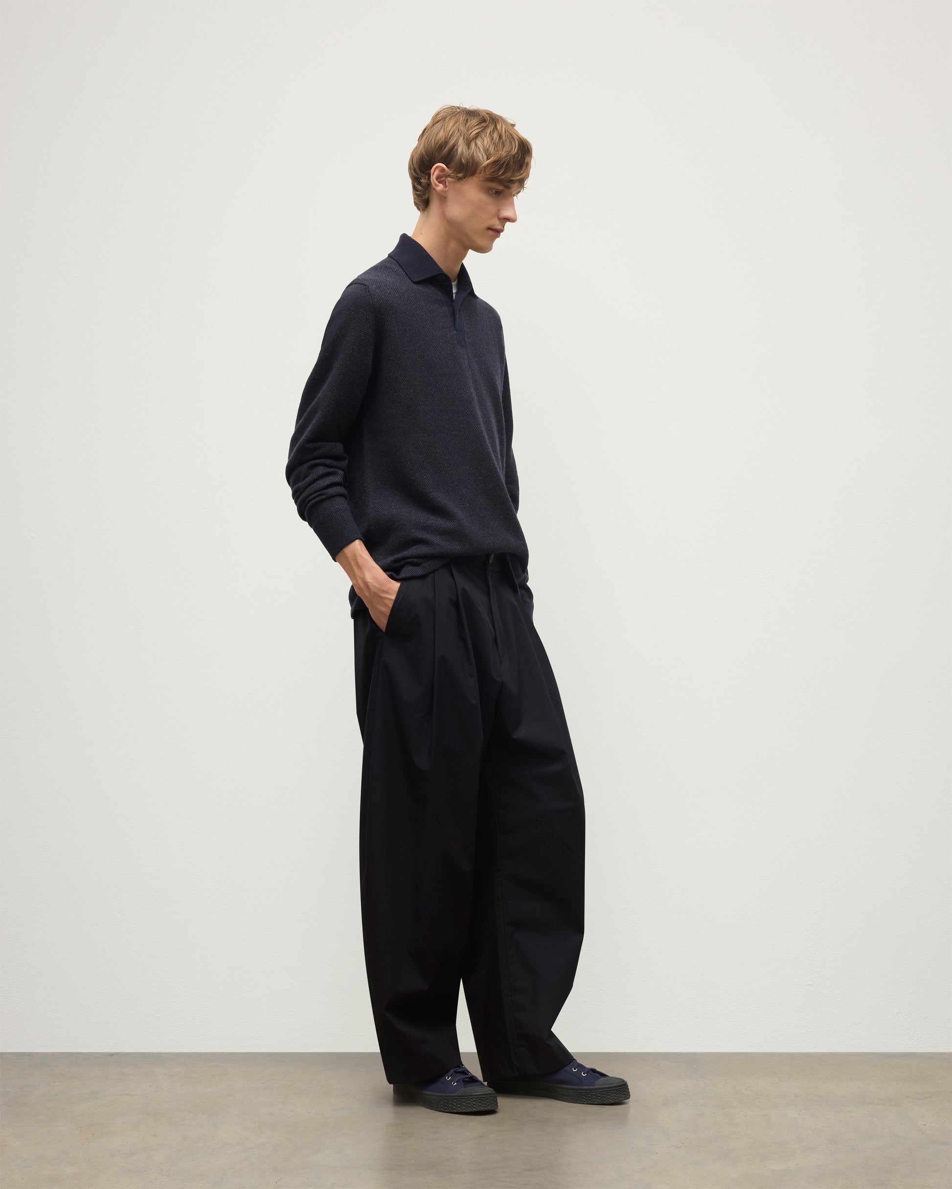 MODEL WEARS JOHNSTONS OF ELGIN MENS TWEEL RUGBY SHIRT NAVY & DARK GREY 100% CASHMERE  OVER A WHITE T-SHIRT WITH GREY TROUSERS KAP05727Q25937