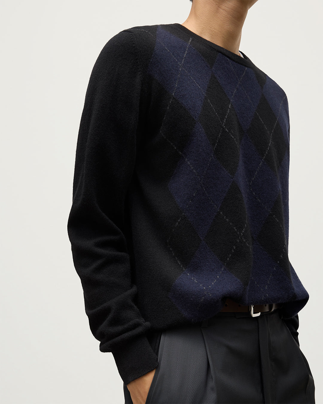 MODEL WEARING JOHNSTONS OF ELGIN MENS BLACK ARGYLL CREW SWEATER 100% CASHMERE OVER A WHITE T-SHIRT KAP05747JU1599