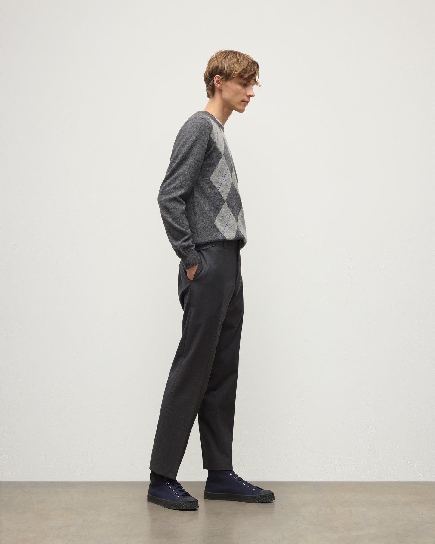 MODEL WEARS JOHNSTONS OF ELGIN MENS ARGYLL CREW SWEATER GREY & BROWN 100% CASHMERE WITH GREY TROUSERS KAP05747JU1601