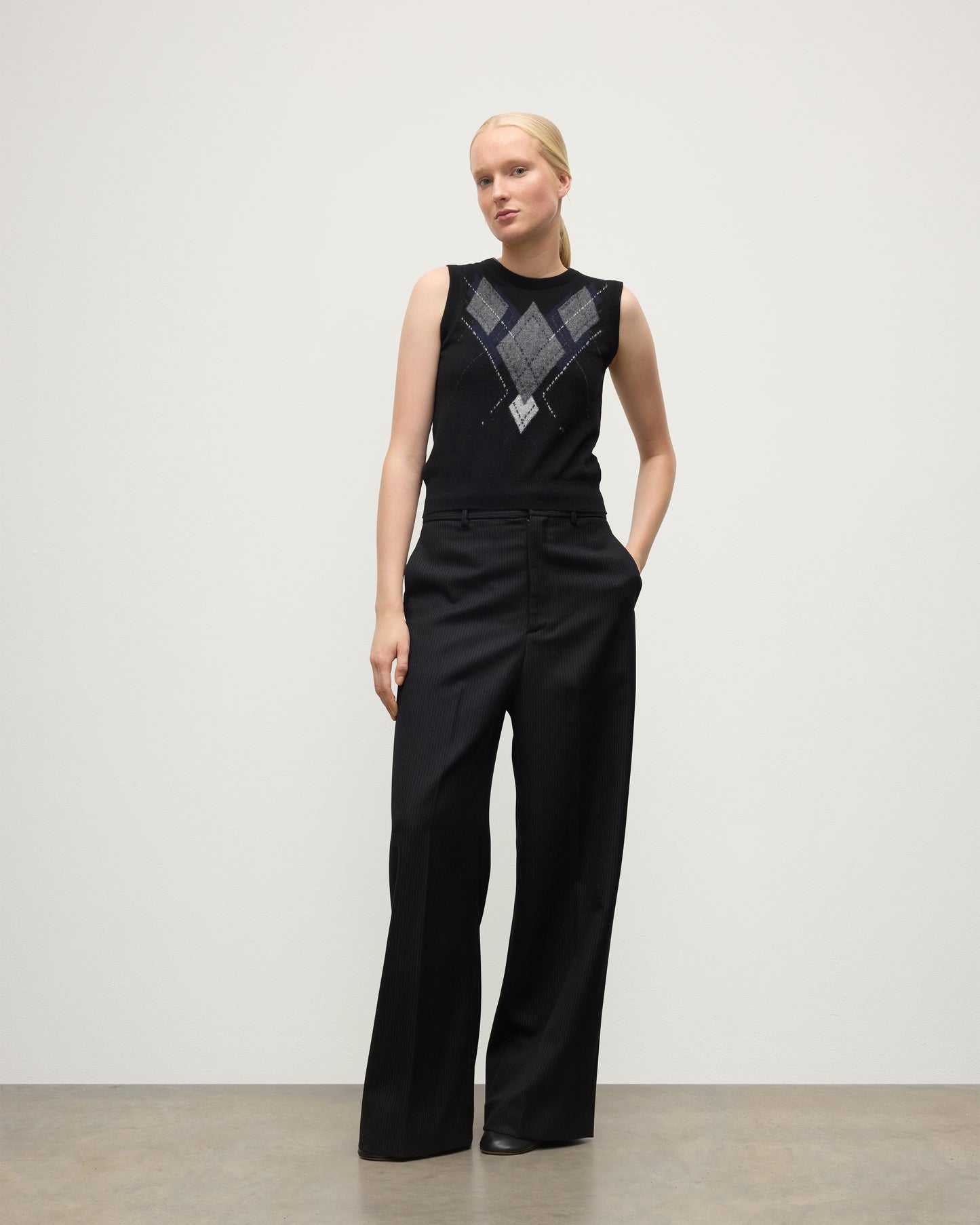 MODEL WEARING JOHNSTONS OF ELGIN WOMENS ARGYLL LE JABOTS SLEEVELESS CREW BLACK 100% CASHMERE WITH BLACK TROUSERS KAP05766JU1609