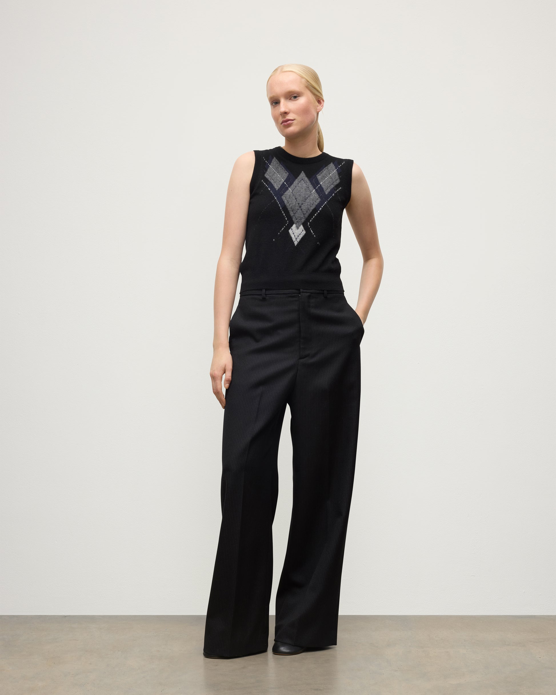 MODEL WEARING JOHNSTONS OF ELGIN WOMENS ARGYLL LE JABOTS SLEEVELESS CREW BLACK 100% CASHMERE WITH BLACK TROUSERS KAP05766JU1609