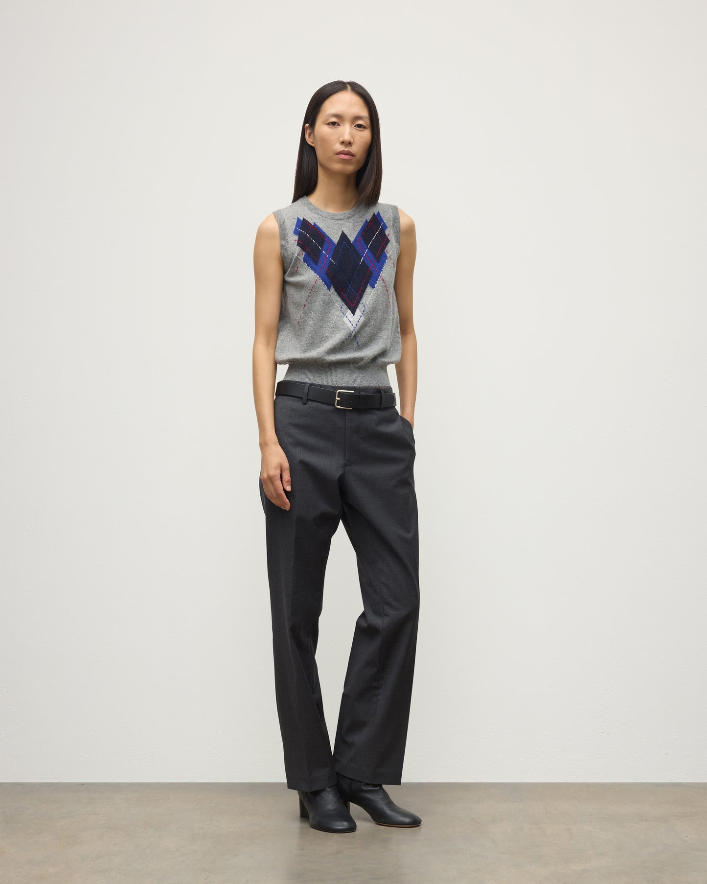 MODEL WEARS JOHNSTONS OF ELGIN WOMENS ARGYLL LE JABOTS SLEEVELESS CREW GREY 100% CASHMERE WITH BELTED GREY TROUSERS AND BLACK BOOTS KAP05766JU1611