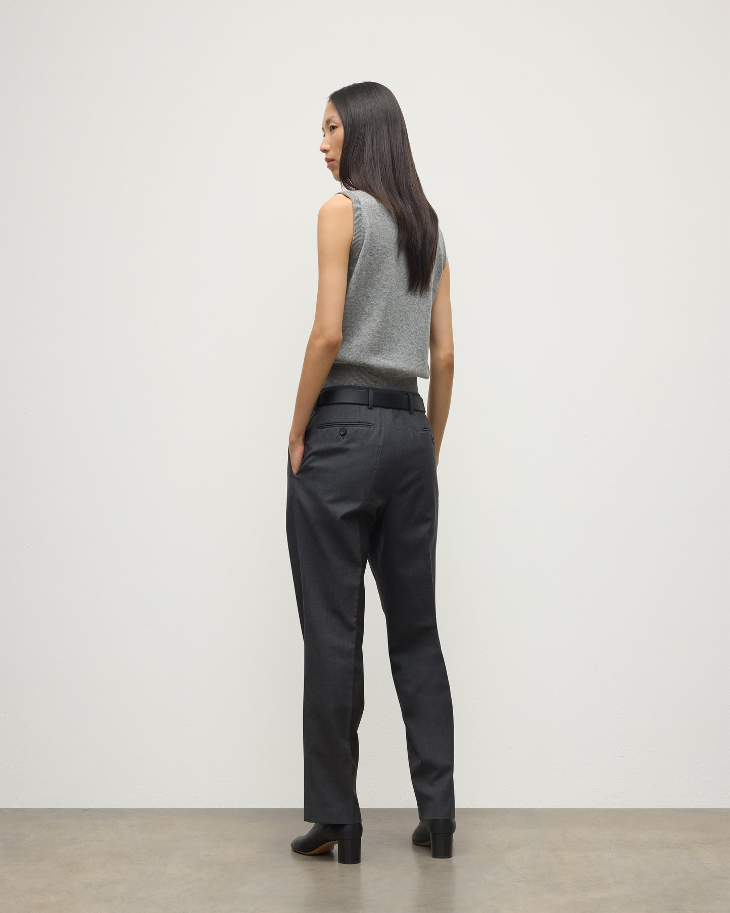 MODEL WEARS JOHNSTONS OF ELGIN WOMENS ARGYLL LE JABOTS SLEEVELESS CREW GREY 100% CASHMERE WITH BELTED GREY TROUSERS AND BLACK BOOTS KAP05766JU1611