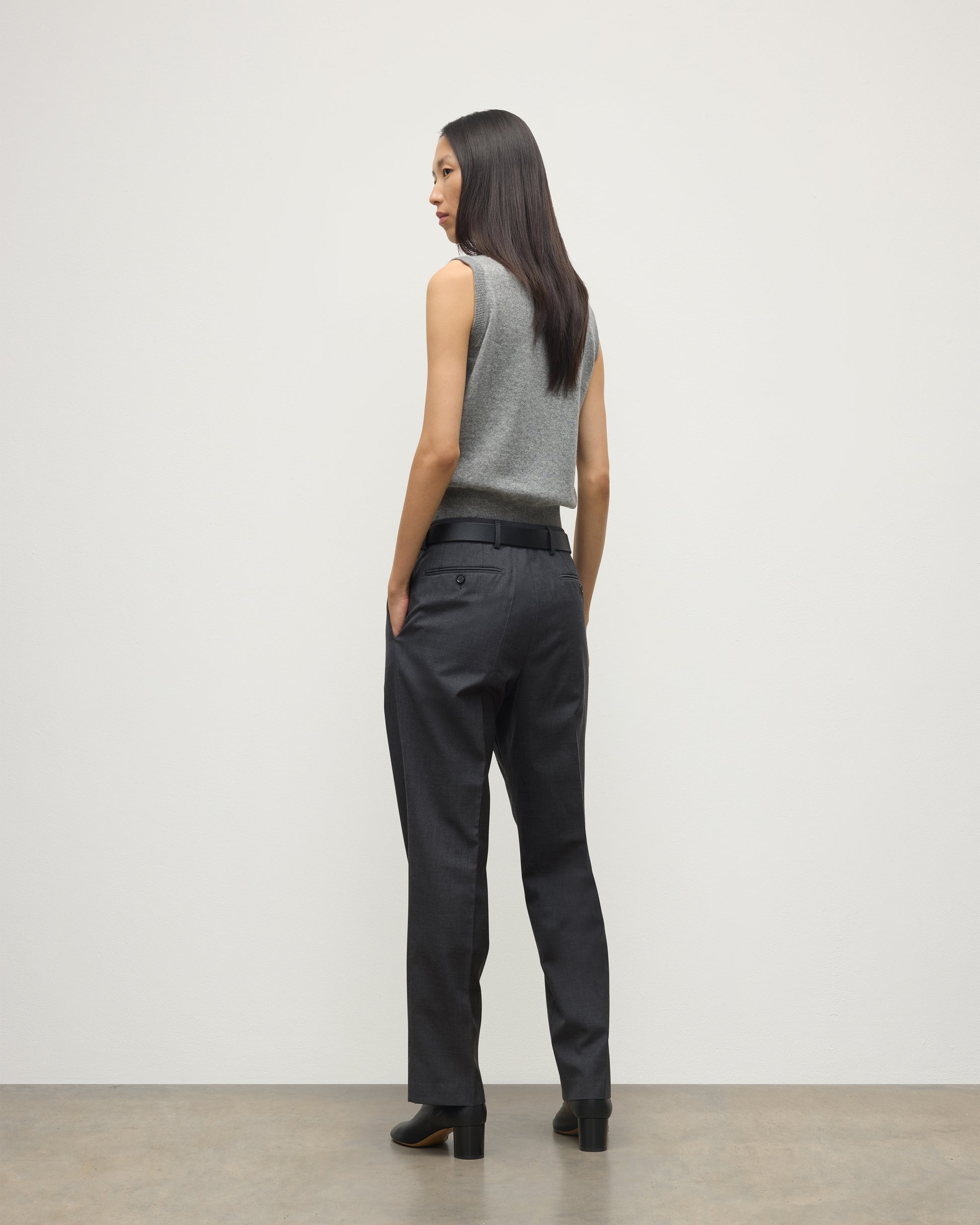 MODEL WEARS JOHNSTONS OF ELGIN WOMENS ARGYLL LE JABOTS SLEEVELESS CREW GREY 100% CASHMERE WITH BELTED GREY TROUSERS AND BLACK BOOTS KAP05766JU1611