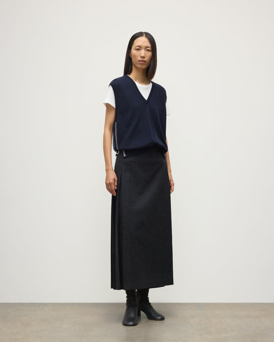 MODEL WEARS JOHYNSTONS OF ELGIN WOMENS TILDA SLEEVELESS VEE NAVY 100% CASHMERE WITH LE KILT JOHNSTONS OF ELGIN CASHMERE KILT IN CHARCOAL KAP05767Q25968