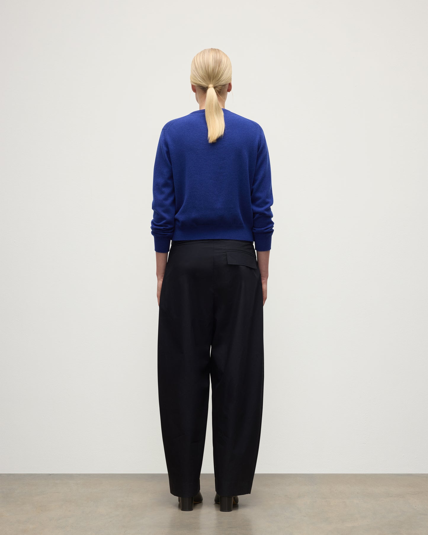 MODEL WEARS JOHNSTONS OF ELGIN WOMENS LUNAN CLASSIC CREW SWEATER BLUE  WITH BLACK TROUSERS KAP05784SD5326