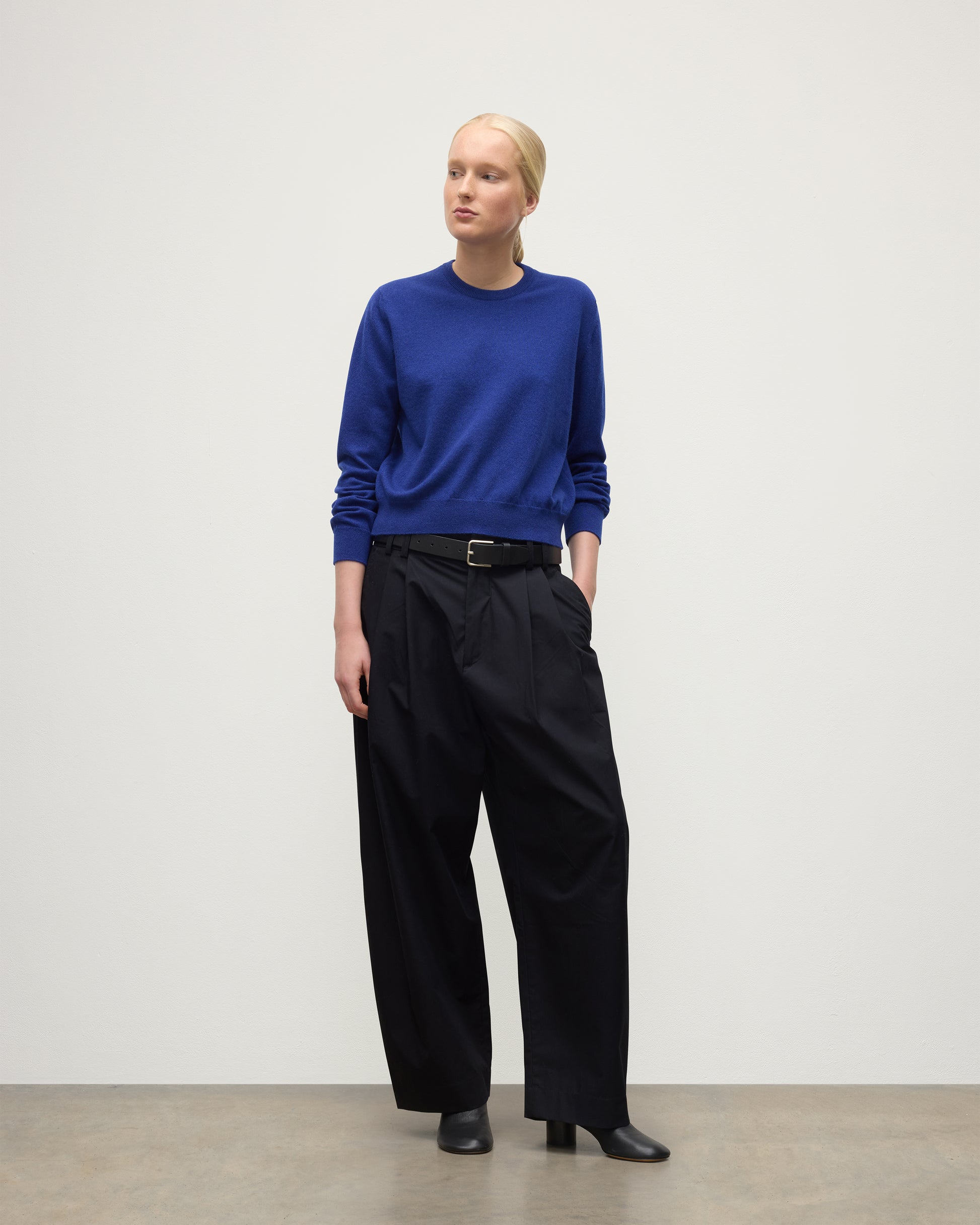 MODEL WEARS JOHNSTONS OF ELGIN WOMENS LUNAN CLASSIC CREW SWEATER BLUE  WITH BLACK TROUSERS KAP05784SD5326