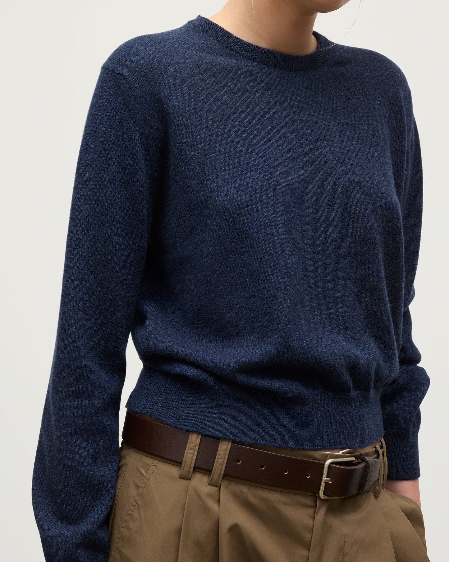MODEL WEARS JOHNSTONS OF ELGIN WOMENS LUNAN CLASSIC CREW SWEATER NAVY WITH BELTED  BROWN TROUSERS KAP05784HD7350