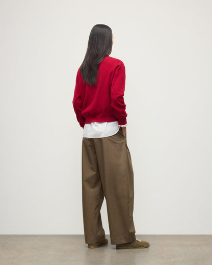 MODEL WEARING JOHNSTONS OF ELGIN WOMENS LUNAN CLASSIC VEE SWEATER RED 100% CASHMERE OVER WHITE SHIRT WITH BROWN TROUSERS KAP05807SE5325