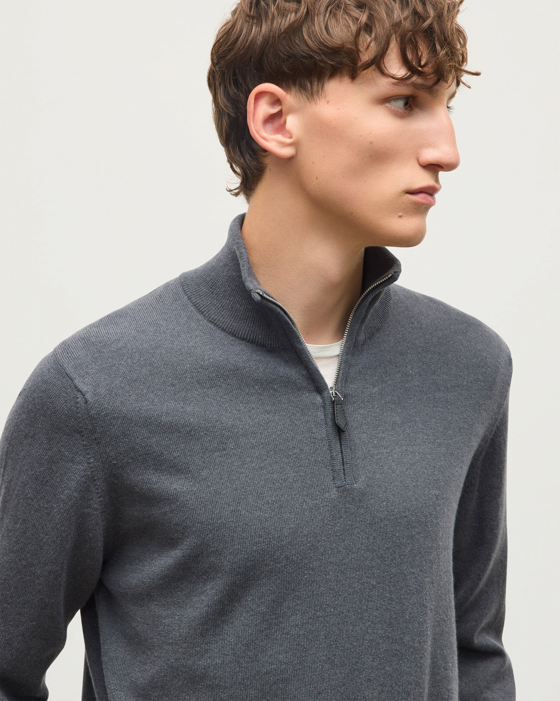 A man wearing a dark gray quarter-zip pullover sweater over a white undershirt, shown in a close-up profile shot against a light gray background. JOHNSTONS OF ELGIN REUBEN HALF ZIP SWEATER CASHMERE ZIP NECK SWEATER - 2 PLY GREY 100% CASHMERE KAP05961SA7216