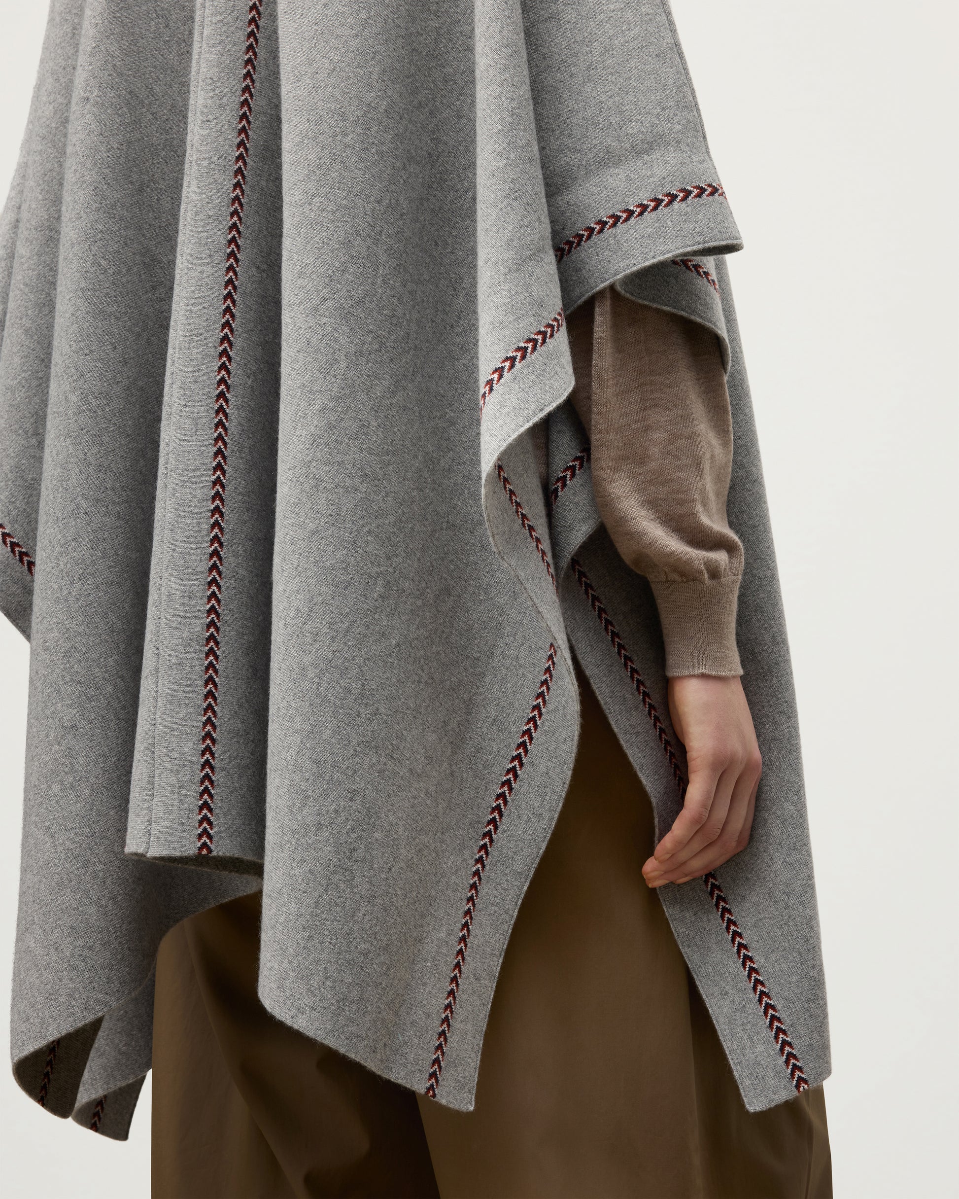 MODEL WEARS JOHNSTONS OF ELGIN WOMENS HAWK PONCHO LIGHT GREY 100% CASHMERE OVER A NATURAL CASHMERE SWEATER  KAU05769Q25974O/S