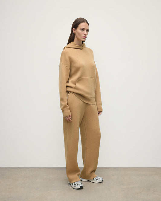 Model wears Johnstons of Elgin AW25 Women's Knitwear Camel & Natural Double-Face Camel Cashmere Hoodie Side View KBA01034Q25325