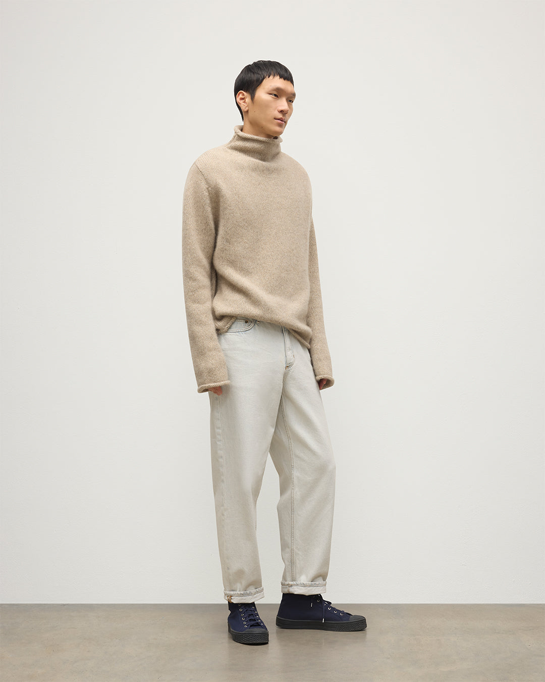 MALE MODEL WEARING JOHNSTOS OF ELGIN KESTER FUNNEL NECK SWEATER NATURAL 100% CASHMERE WITH WHITE JEANS KBB01067HB4453
